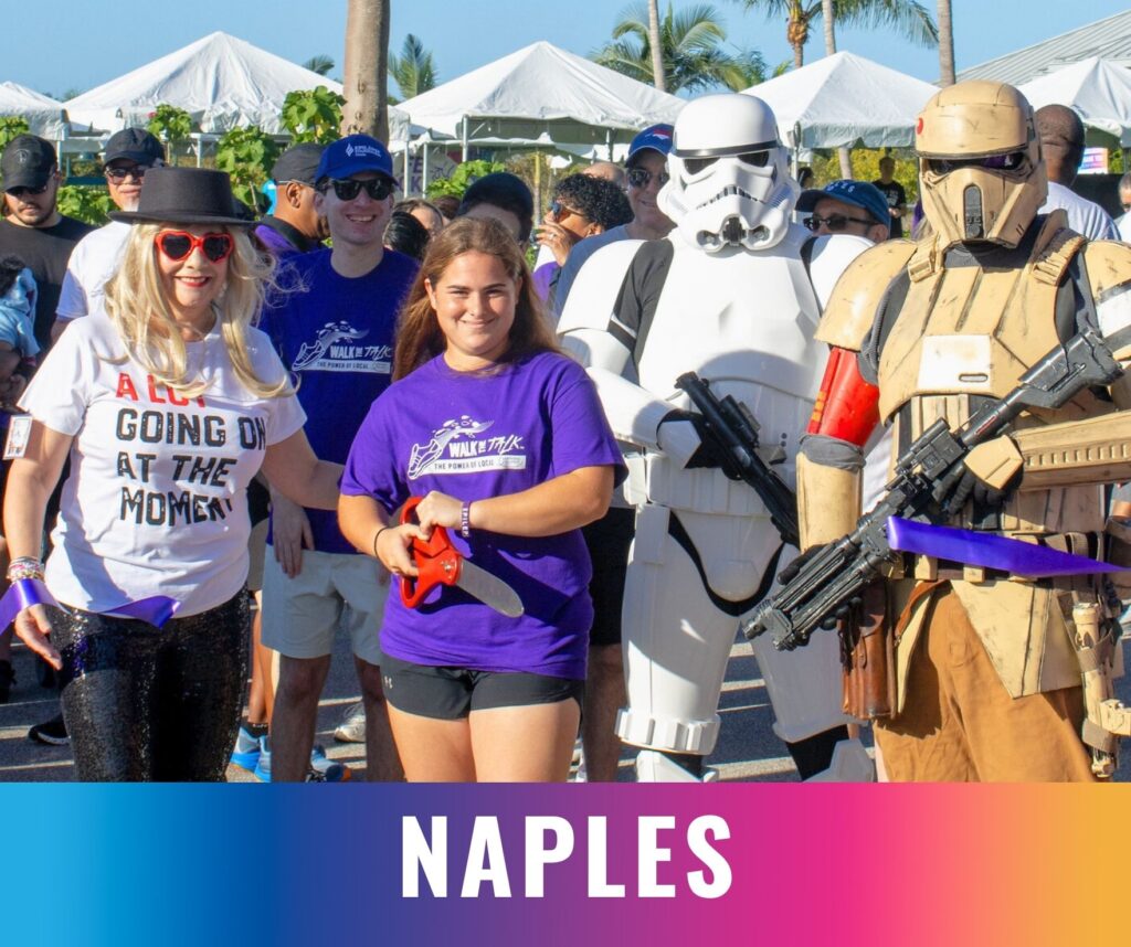 Participants gather at the start of the Walk the Talk epilepsy awareness event in Naples, including community members and costumed volunteers.