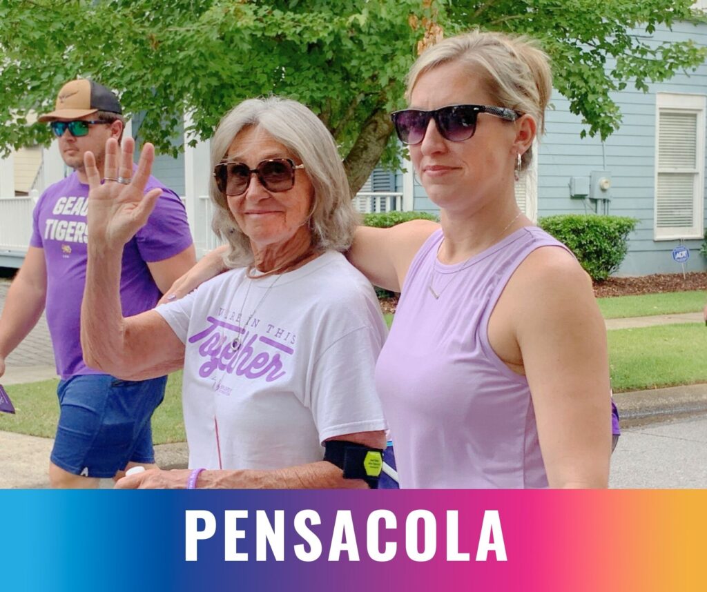 Two participants walk side by side and wave during the Walk the Talk epilepsy awareness event in Pensacola.